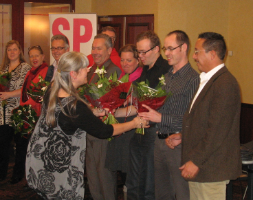 De top-12 kandidaten ontvangen bloemen en felicitaties nadat ze door de Limburgse SP'ers gekozen zijn